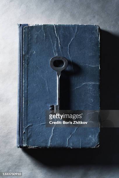 old key on top of an old book. - old book cover stock pictures, royalty-free photos & images