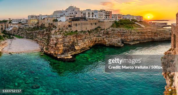 scenic view of sea by buildings against sky during sunset,polignano a mare,bari,italy - bari stock pictures, royalty-free photos & images