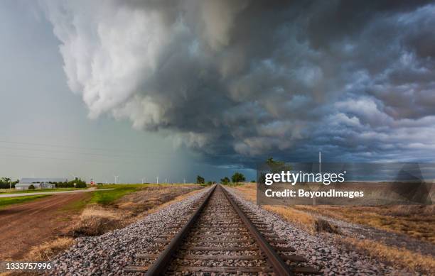 severe storm with torrential rain over railroad tracks and farm land - threats stockfoto's en -beelden