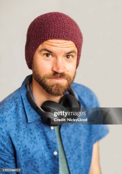 cool young man smiling while wearing headphones and a beanie - dj portrait stock pictures, royalty-free photos & images