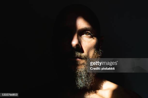 dramatisches leichtes selbstporträt: bärtiger mann - augen mann stock-fotos und bilder