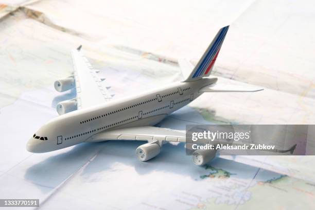items for summer holidays: a mock-up of a commercial aircraft, a map and a travel plan. tourist layout - a set and accessories of a traveler, on a wooden background. the concept of open borders for a happy journey. a copy of the text space. - travel insurance stock pictures, royalty-free photos & images