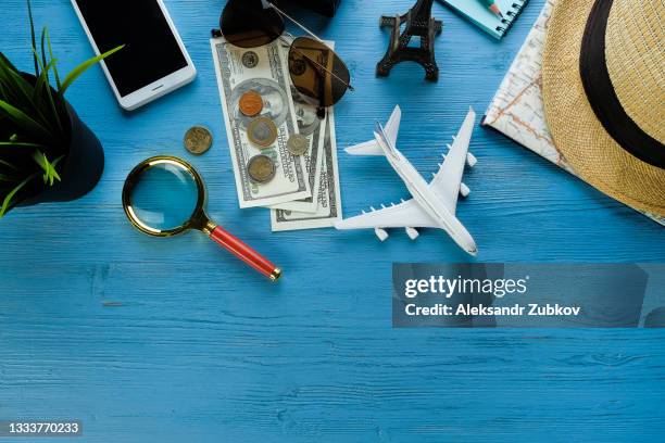 items for summer holidays: camera, sunglasses, cash, straw hat, mobile phone, map and travel plan. tourist layout-set and accessories of the traveler, on a wooden background. open borders concept for free happy travel. a copy of the text space. - happy holidays around the world stock pictures, royalty-free photos & images