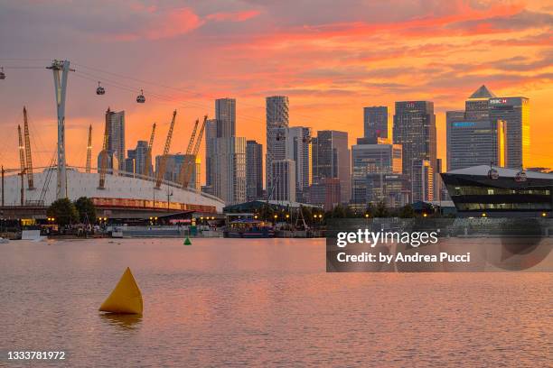 london skyline at sunset from royal victoria dock, london, united kingdom - canary wharf stock-fotos und bilder