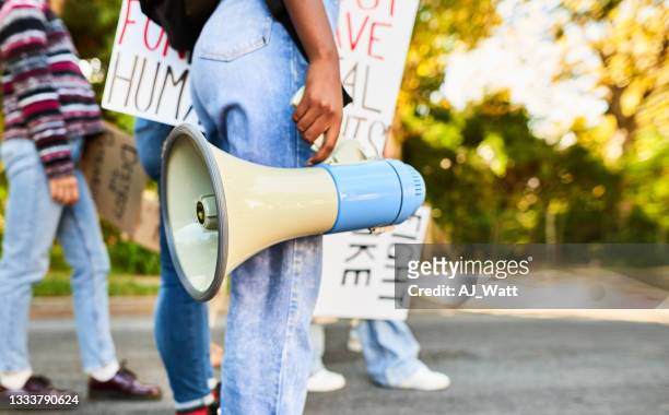 donna in piedi con un megafono durante una marcia del giorno dei diritti delle donne - manifestante foto e immagini stock