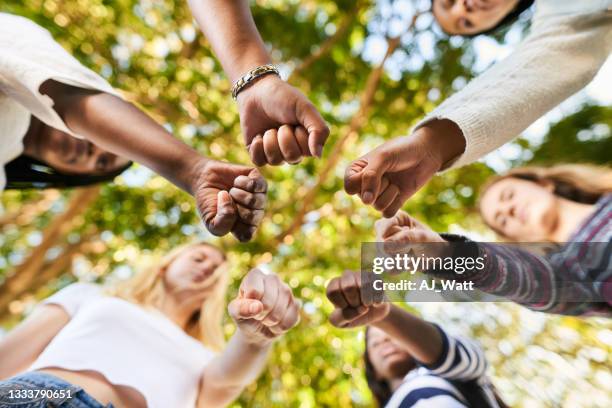 teenage girls standing with fists in a circle before an equality protest - knytnäve bildbanksfoton och bilder