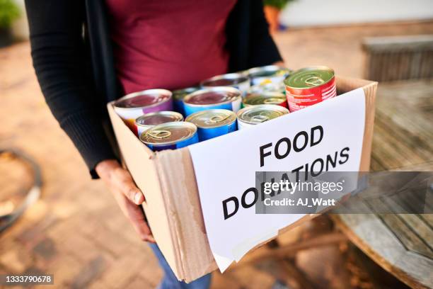 primer plano de una joven que lleva una caja de donaciones de alimentos - food pantry fotografías e imágenes de stock