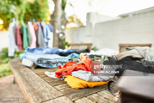 second hand clothing for sale at a garage sale - garage sale stock pictures, royalty-free photos & images