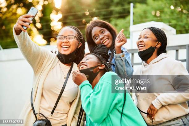 grupo sorridente de adolescentes tirando máscaras para tirar selfies juntos do lado de fora - absence - fotografias e filmes do acervo