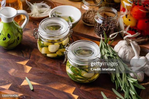 kitchen pantry. making preserved garlic in oil - confit stock pictures, royalty-free photos & images