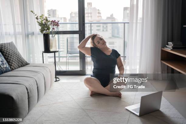 woman stretching and exercising at home - covid-19 guidance stock pictures, royalty-free photos & images