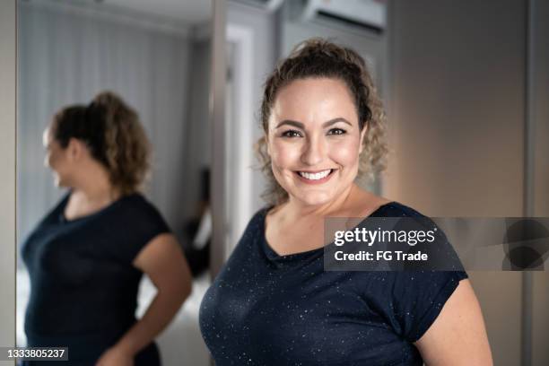 portrait of a mid adult woman in front of mirror at home - chubby stock pictures, royalty-free photos & images
