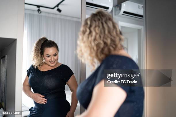 jolie femme s’habillant devant un miroir à la maison - voluptuous ladies photos et images de collection