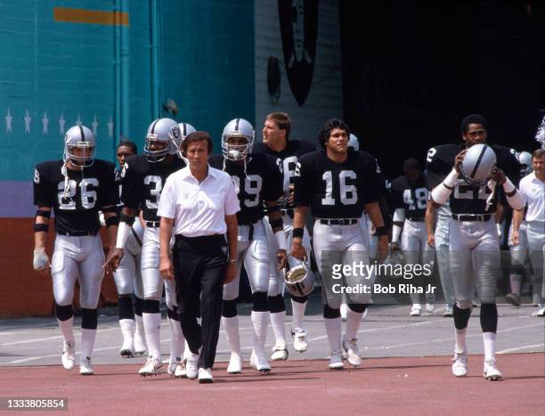 Los Angeles Raiders Head Coach Tom Flores escorts his team onto the field during game of Los Angeles Raiders against Miami Dolphins, August 19, 1984...
