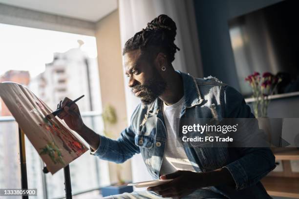 man painting on canvas at home - painter artist stockfoto's en -beelden