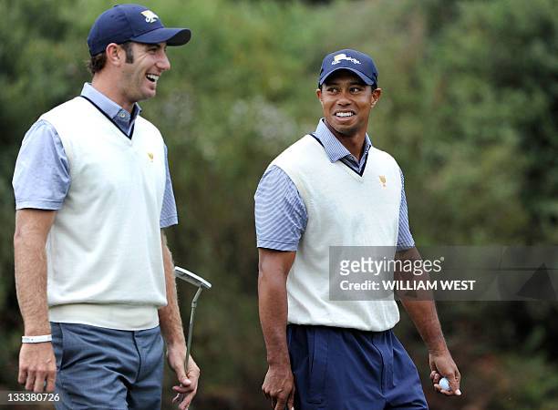 Dustin Johnson and Tiger Woods of the US laugh during their match on the third day of the President's Cup tournament played at the Royal Melbourne...