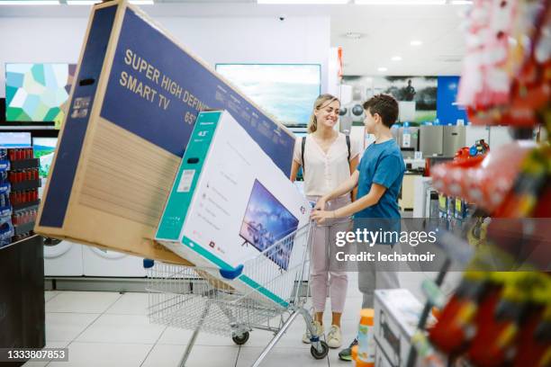 mamá e hijo comprando televisores grandes en el centro comercial - electronics industry fotografías e imágenes de stock