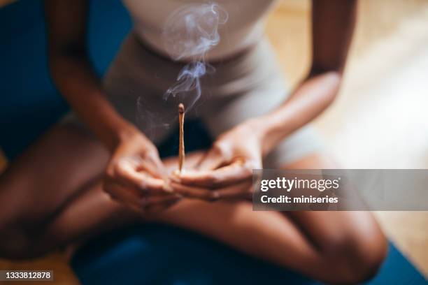 an anonymous woman enjoying incense stick at home - wierook stockfoto's en -beelden