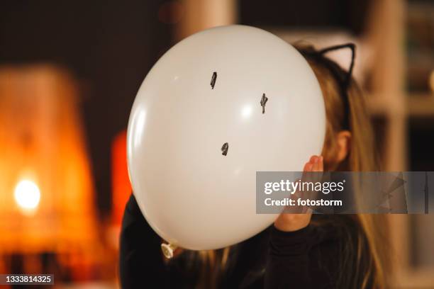 little girl holding a balloon she drew a ghost on, in front of her face - ghost player stock pictures, royalty-free photos & images