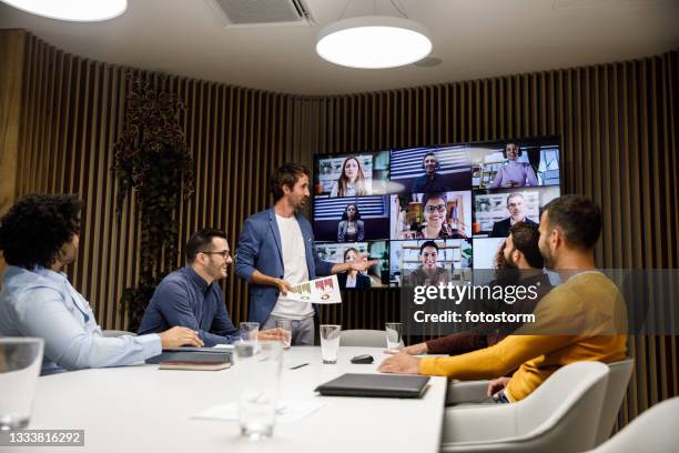 gruppe von geschäftsleuten, die eine videokonferenz mit ihren kollegen haben - video conference stock-fotos und bilder