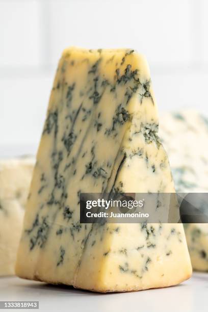 pieces of stilton cheese over a kitchen counter - gorgonzola stockfoto's en -beelden