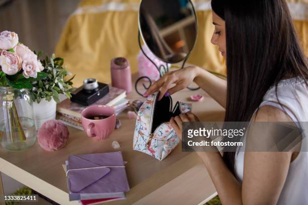 looking for mascara in her make up bag while getting ready - vanity bag stock pictures, royalty-free photos & images