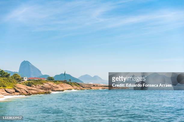 view of the copacabana fort at the entrance of the guanabara bay with the sugarloaf mountain - arpoador beach stock pictures, royalty-free photos & images