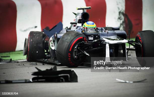 Brazilian Williams Formula One team racing driver Bruno Senna sitting in the cockpit of his severely damaged FW34 racing car and surrounded by broken...