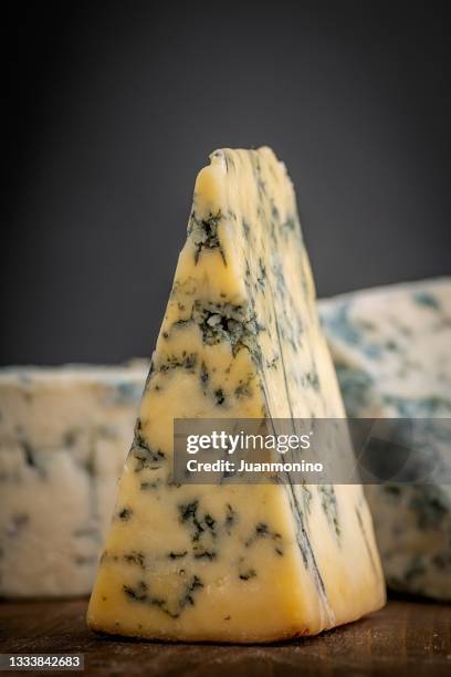 pieces of stilton cheese over a wooden counter - roquefort stock pictures, royalty-free photos & images