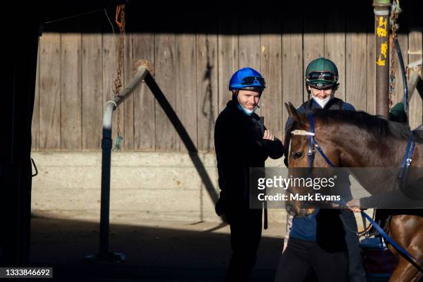 Jason Collett and Tommy Berry smile and look on during a trackwork session at Royal Randwick Racecourse on August 13, 2021 in Sydney, Australia.