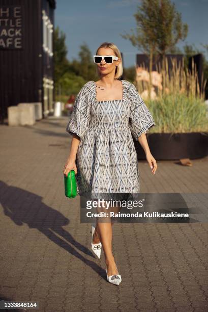 Justyna Czerniak wearing dress and green bag outside Rotate during Copenhagen fashion week SS22 on August 12, 2021 in Copenhagen, Denmark.
