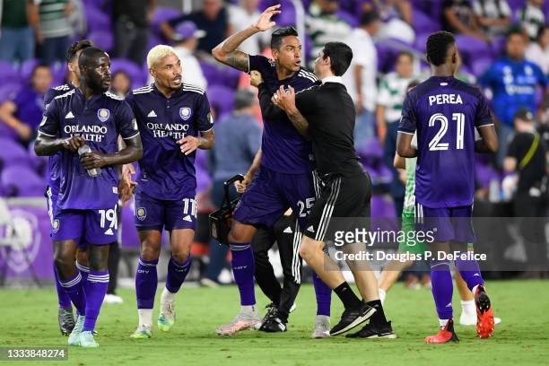 Junior Urso of Orlando City SC reacts with teammate Antonio Carlos after being issued a red card after losing to the Santos Laguna by a score of 1-0...