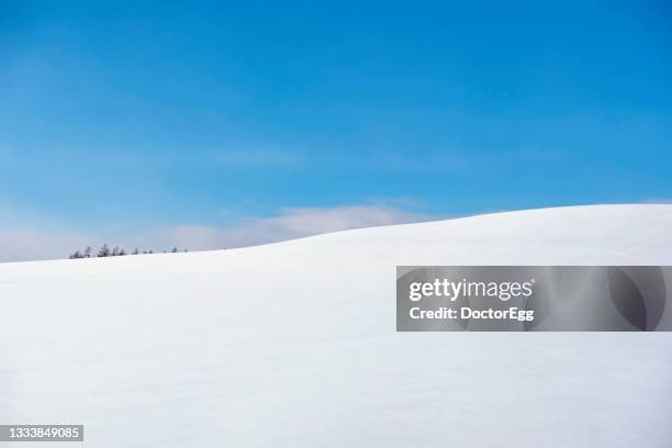 white snow hill with blue sky background in winter at biei patchwork road, hokkaido, japan - kamikawa hokkaido stock-fotos und bilder