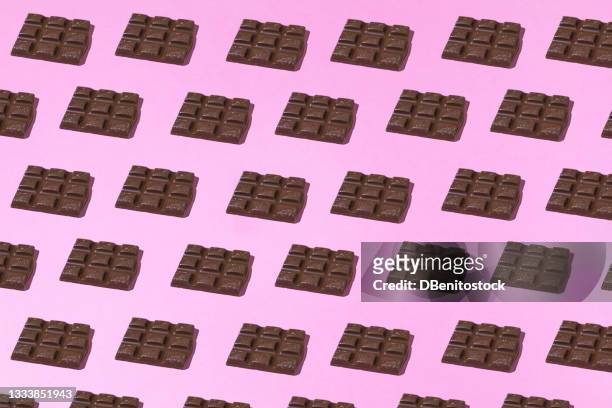 chocolate tablets pattern with hard shadow on pink background. group, design and sweet concept - veleiding stockfoto's en -beelden