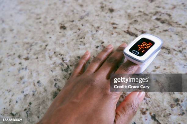 woman uses pulse oximeter - pulse oximeter stockfoto's en -beelden