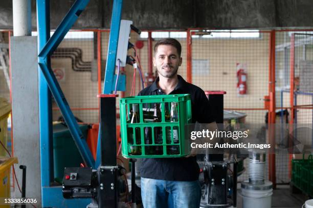 portrait of  recycling center worker handling crate with empty bottles - material handling stock pictures, royalty-free photos & images