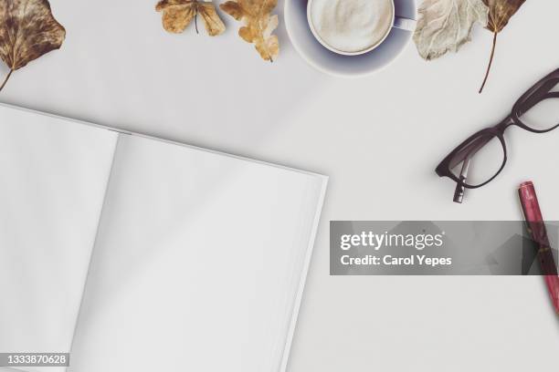 blank magazine page. workspace with magazine mock up fall autumn leaves hot coffee and eyeglasses - magazines on table bildbanksfoton och bilder