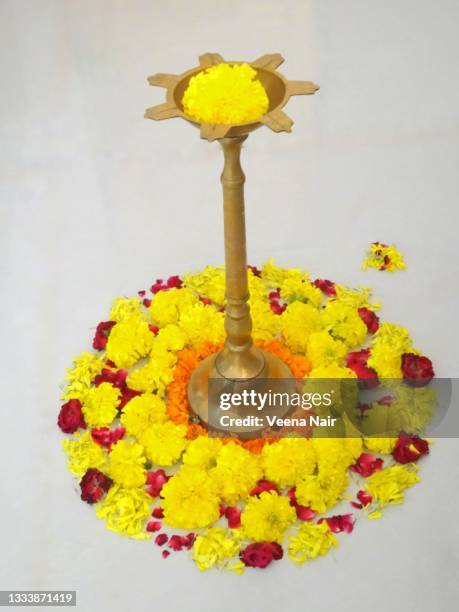 onam/flower carpet/pookalam with brass lamp in the middle/kerala - pookalam stock pictures, royalty-free photos & images