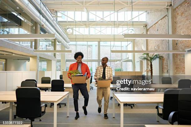 black businessmen in 20s and 30s moving into new office - bezittingen stockfoto's en -beelden