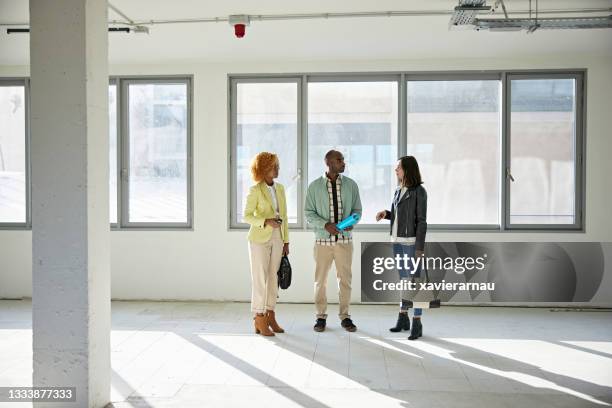 businesswomen in 20s and 30s discussing property with broker - commercial property imagens e fotografias de stock