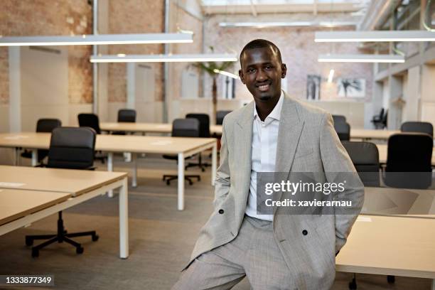 retrato interior de un joven hombre de negocios negro en una oficina moderna - desabrochado fotografías e imágenes de stock