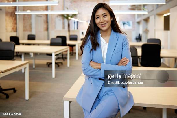 büroporträt einer selbstbewussten koreanischen geschäftsfrau mitte der 30er jahre - blue suit stock-fotos und bilder