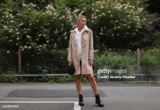 Scarlett Gartmann wearing Burberry beige coat, Weekday white sweater, Helmut Lang black shorts, Chanel black boots and Bottega Veneta black mini...