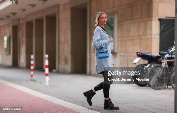 Scarlett Gartmann wearing Zara black pants, LeGer black shirt, Miu Miu blue long cardigan, Hermes blue bag and Chanel black boots on August 07, 2021...