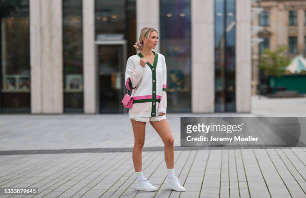Scarlett Gartmann wearing Resume cardigan, white Chanel sneaker and pink Chanel Wallet on Chain and A Lot Less beige shorts on August 07, 2021 in...