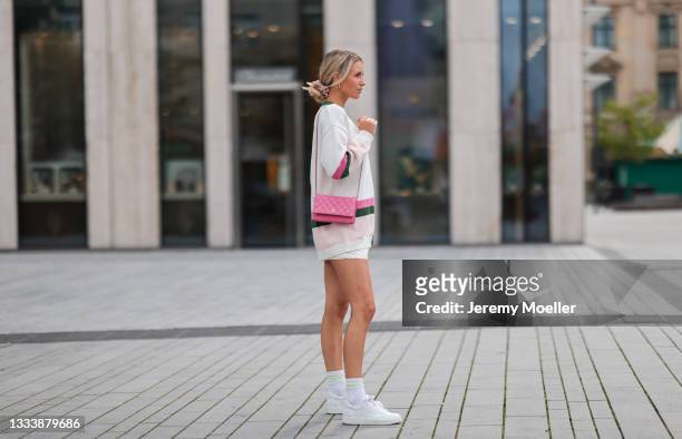 Scarlett Gartmann wearing Resume cardigan, white Chanel sneaker and pink Chanel Wallet on Chain and A Lot Less beige shorts on August 07, 2021 in...