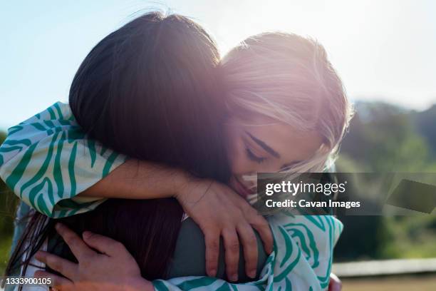 smiling girls hugging each other - adult sibling stock pictures, royalty-free photos & images