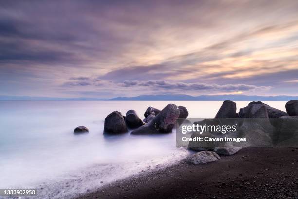 view of the sea and tetrapods at sunrise from the beach, shizuoka prefecture, japan - cinematic sunrise stock pictures, royalty-free photos & images