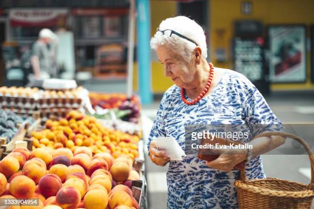 femme âgée dans la ville - marché de plein air photos et images de collection