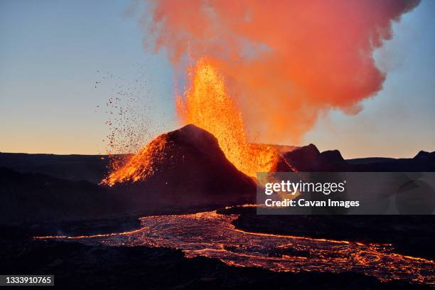 hot lava erupting from volcano at sunset - vulkaanlandschap stockfoto's en -beelden